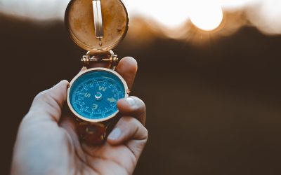 A person holding a compass with a blurred background