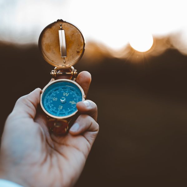 A person holding a compass with a blurred background